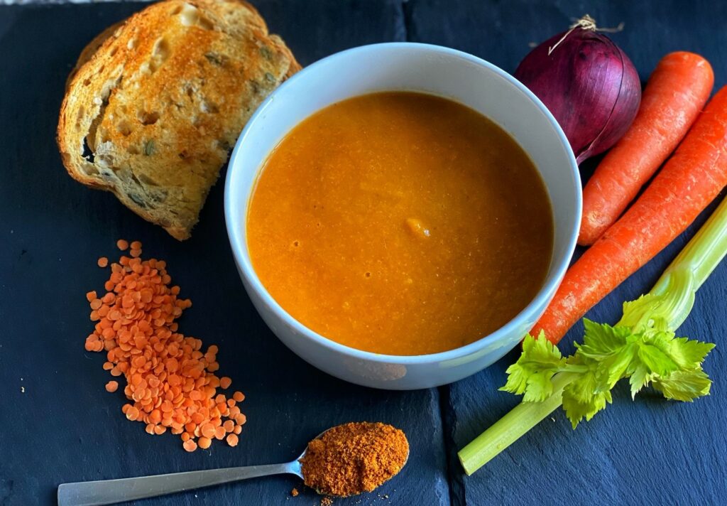 A bowl of spicy carrot and lentil soup.